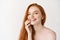 Beauty and skincare. Close-up of happy redhead woman with pale perfect skin, laughing and showing white teeth, standing