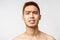 Beauty, skincare and men health concept. Headshot ot troubled and nervous young asian man with naked torso, grimacing