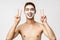 Beauty, skincare and spa concept. Cheerful young asian guy with naked torso applied skin routine cosmetics, facial mask