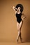 Beauty Slim Woman in Black Wide Broad Hat over Beige. Perfect Body and Legs Silhouette. Fit Ballerina Expressive Dancing in Shoes
