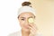 Beauty and spa condo, woman holding cucumber. Young woman with facial mask holding cucumber slices on white background