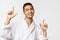Beauty, spa and leisure concept. Portrait of cheerful, handsome enthusiastic asian man in bathrobe, pointing fingers up
