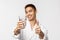 Beauty, spa and technology concept. Portrait of satisfied handsome asian man in bathrobe staying healthy, wake-up and