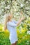 Beauty spring girl portrait over blooming tree with flowers