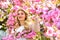 Beauty of spring nature. attractive woman with makeup. girl has long curly blonde hair. healthy beauty. pink sakura
