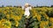 Beauty sunlit woman on yellow sunflower field Freedom and happiness concept. Happy girl outdoors