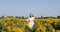 Beauty sunlit woman on yellow sunflower field Freedom and happiness concept. Happy girl outdoors/
