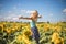 Beauty sunlit woman on yellow sunflower field Freedom and happiness concept. Happy girl outdoors