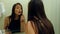 Beauty teenage girl applying make up and admiring herself in the mirror