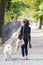 Beauty woman with her dog playing outdoors. Woman walking Labrador Retriever in park. Girl with dog on the street