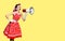 Beauty woman holding megaphone, shout advertising something. Girl in pin up style. Yellow color background with mock up copy space