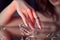 Beauty Woman holds big diamond in hand while lying on table. Beautiful hands, professional manicure, large diamond brilliant