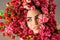 Beauty woman makeup face with red roses flower wreath on head