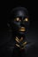 Beauty woman painted in black skin color body art, gold makeup lips eyelids, fingertips nails in gold color paint. Professional