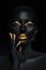 Beauty woman painted in black skin color body art, gold makeup lips eyelids, fingertips nails in gold color paint. Professional