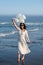 Beauty woman raising white balloons on beach