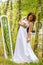 A beauty woman trying on a wedding dress in front of mirror in the forest, morning of the bride, natural beauty