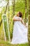 A beauty woman trying on a wedding dress in front of mirror in the forest, morning of the bride, natural beauty