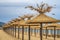 Beauty wooden umbrellas of empty sandy beach