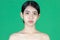 Beauty young Asian half naked woman over green isolated background. Healthy skin care concept