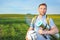 Beauty young man on picnic with backpack and rackets for a badbotton, ball smiling against a green meadow