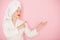 Beauty Young woman with red lips standing in the bath robe and towel on the head on the pink background. Studio shot