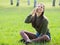 Beautyful girl talking on the phone sitting on the fresh grass