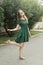 Beautyful, smiling teen age girl in green dress. Outdoor summer day. Free happy woman