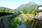 Beautyful View of Oita river flowing through Yufuin city with Mount Yufu in Background and clear sky  in summer.