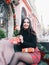 Beautyful young girl unpacks her box with a christmas gift. Woman with a gift in her hands stands on the background of Christmas d