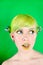 Beautyful young woman with green hair licking her lip on green background