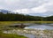 A beaver lodge sits on a small mountain lake.