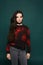 Beaytiful and fashionable brunette teen model girl in stylish grey jeans and in the black sweatshirt with red pattern