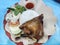 Bebek goreng or fried duck with rice and vegetable on blue background