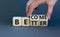 Become better symbol. Businessman turns wooden cubes and changes the concept word Better to Become. Beautiful grey table grey