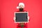 Become professional Mr Santa Claus. Bearded man hold empty blackboard. Hipster santa red background. Attend Santa school