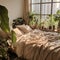 Bed with beige bedding in room with many green houseplant