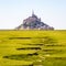 The bed of a dried-up stream snaking in the salt meadow opposite the Mont Saint-Michel tidal island in Normandy, France