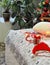 A bed with a gift, beads and a Santa Claus hat on the bed with a decorated Christmas tree. The concept of the process of