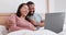 Bed, laptop and couple laughing, talking and reading funny email, meme joke or consulting about humour blog article