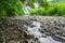 Bed of a mountain river with boulders and pebble, small water