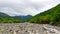 Bed of a mountain river with low water boulders and pebble