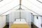 Bed surrounded by mosquito net inside of glamping tent, with nightstands