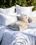 Bed with white patterned linen in the garden in the summer