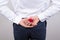 Bedind rear view photo of excited nervous gentleman hiding small bright red box with ring behind back isolated grey background