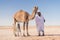 Bedouin, Baby camel and mother camel in Sahara desert among the small sand dunes, beautiful wildlife near oasis. Camels walking in