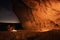 Bedouin in the Crimean cave Kachi-Kalyon is heated by the fire on the background of the starry sky