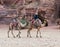 Bedouin - the driver rides a camels and holds another camel in Petra - the capital of the Nabatean kingdom in Wadi Musa city in Jo