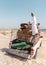 Bedouin man over the white 4x4 off-road car on the Al Khaluf beach in Oman