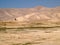 Bedouin rides on donkey through sandy desert